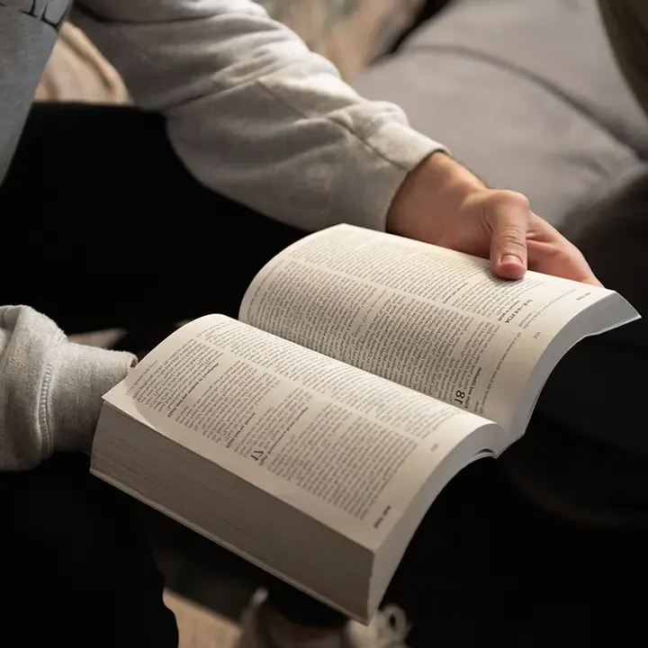 Man holding an open Bible.